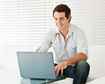 Man die lachend achter de computer zit