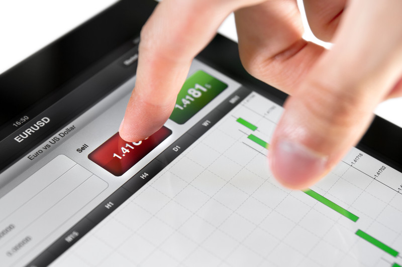 Persoon die via een tablet internationale beleggingen doet.